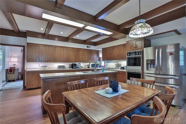 11 Peterson Pl, Wilmington, OH 45177 - kitchen with stainless steel fridge with ice dispenser, wood finished floors, beamed ceiling, a kitchen island with sink, and pendant lighting