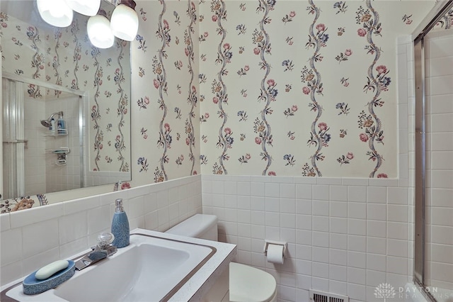 11 Peterson Pl, Wilmington, OH 45177 - bathroom featuring wallpapered walls, tile walls, wainscoting, and a shower