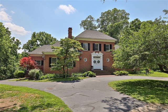 11 Peterson Pl, Wilmington, OH 45177 - colonial home with a chimney, brick siding, curved driveway, and a front yard