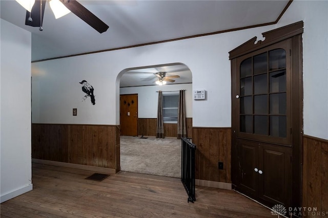 718 Hook Rd, Xenia, OH 45385 - unfurnished room with a ceiling fan, a wainscoted wall, arched walkways, wooden walls, and wood finished floors