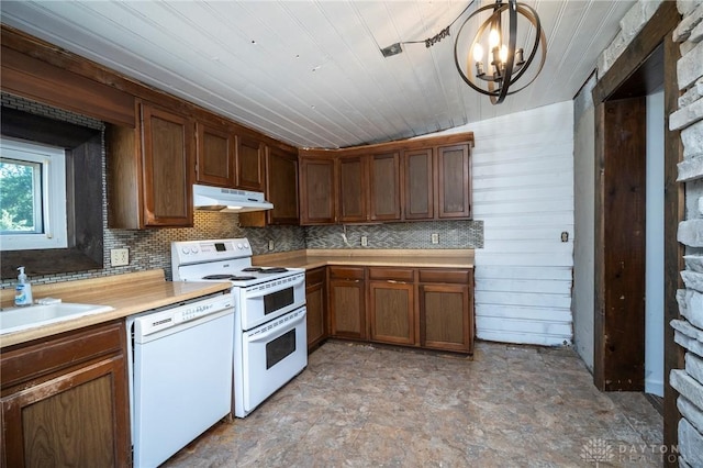 718 Hook Rd, Xenia, OH 45385 - kitchen with white appliances, under cabinet range hood, light countertops, a chandelier, and decorative backsplash