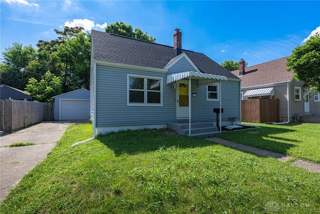 607 Alexander Dr, Dayton, OH 45403 - view of front of house featuring a detached garage, a chimney, an outbuilding, driveway, and a shingled roof