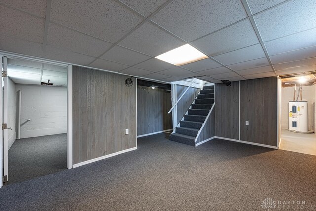 607 Alexander Dr, Dayton, OH 45403 - finished below grade area featuring electric water heater, stairway, carpet flooring, a drop ceiling, and wood walls