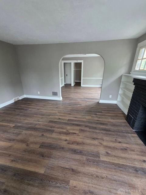 2324 Eastview Unit 2322, Dayton, OH 45405 - unfurnished living room with arched walkways, dark wood-style floors, and a brick fireplace