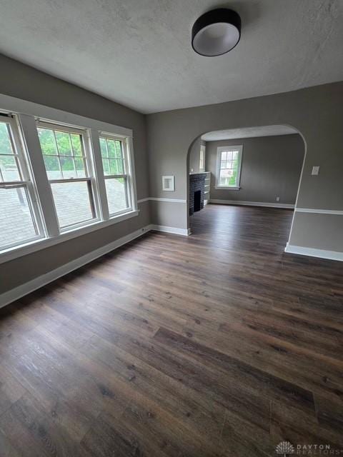2324 Eastview Unit 2322, Dayton, OH 45405 - unfurnished living room with dark wood-style flooring, arched walkways, a brick fireplace, and a textured ceiling
