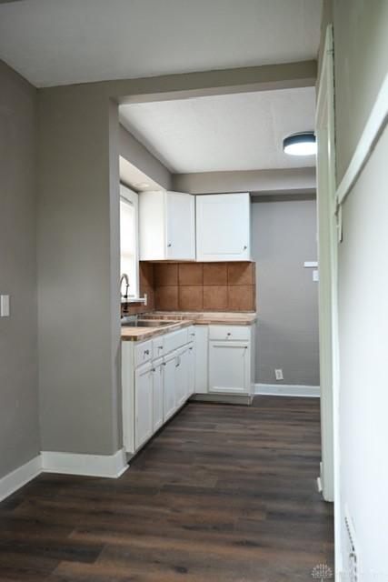 2324 Eastview Unit 2322, Dayton, OH 45405 - kitchen with white cabinets, dark wood finished floors, tasteful backsplash, and light countertops