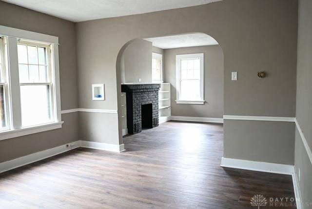 2324 Eastview Unit 2322, Dayton, OH 45405 - unfurnished living room featuring a brick fireplace, wood finished floors, and arched walkways