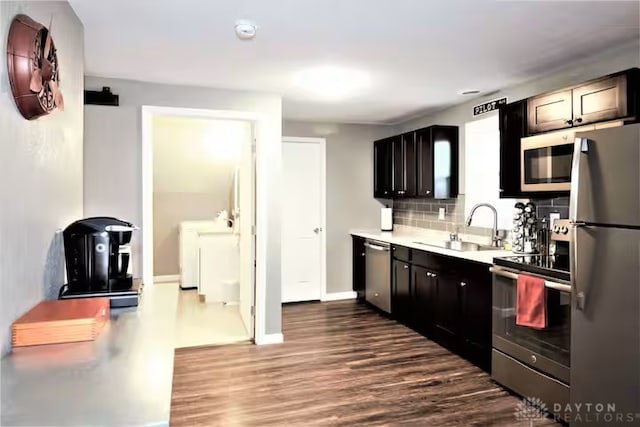 4646 Wayne Meadows Cir Unit 4640, Dayton, OH 45424 - kitchen featuring stainless steel appliances, independent washer and dryer, dark wood-style floors, light countertops, and backsplash