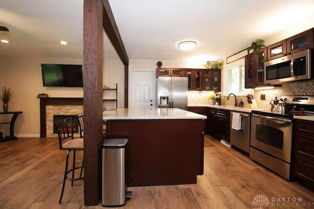 4646 Wayne Meadows Cir Unit 4640, Dayton, OH 45424 - kitchen with stainless steel appliances, a breakfast bar area, backsplash, glass insert cabinets, and a kitchen island