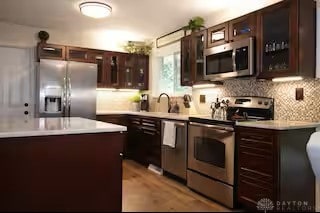 4646 Wayne Meadows Cir Unit 4640, Dayton, OH 45424 - kitchen featuring stainless steel appliances, dark brown cabinetry, decorative backsplash, and light countertops