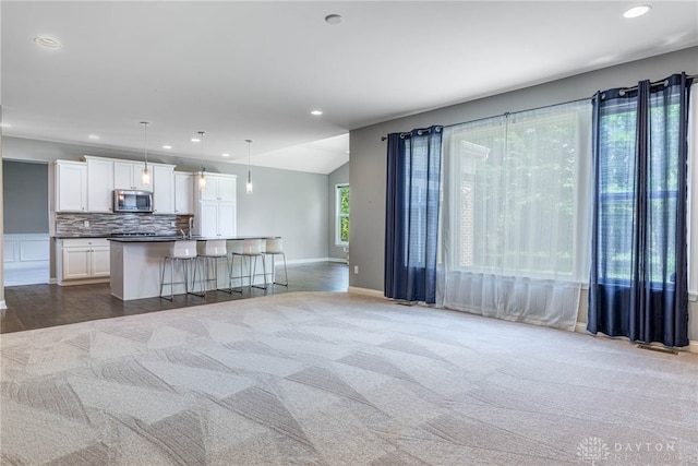 225 Woodstream Dr, Springboro, OH 45066 - kitchen with stainless steel microwave, open floor plan, white cabinetry, decorative backsplash, and recessed lighting
