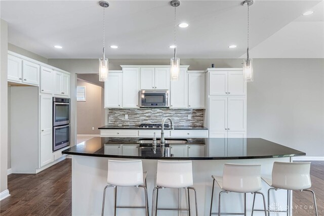 225 Woodstream Dr, Springboro, OH 45066 - kitchen with stainless steel appliances, dark countertops, tasteful backsplash, white cabinets, and recessed lighting