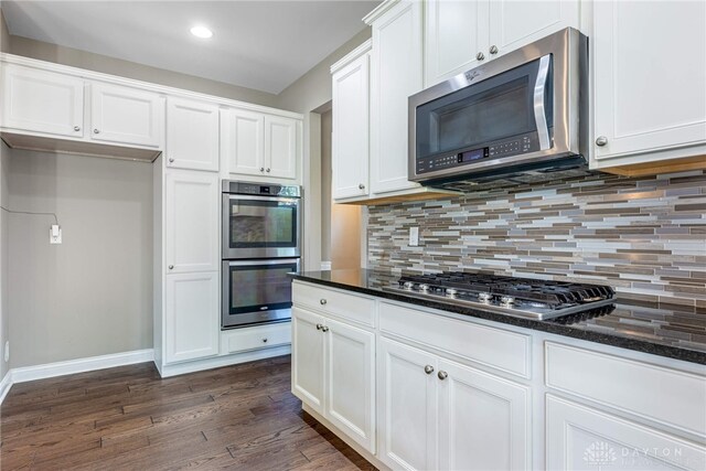 225 Woodstream Dr, Springboro, OH 45066 - kitchen featuring appliances with stainless steel finishes, dark wood-type flooring, decorative backsplash, white cabinets, and recessed lighting