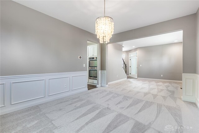225 Woodstream Dr, Springboro, OH 45066 - spare room with a chandelier, light carpet, a decorative wall, a wainscoted wall, and recessed lighting