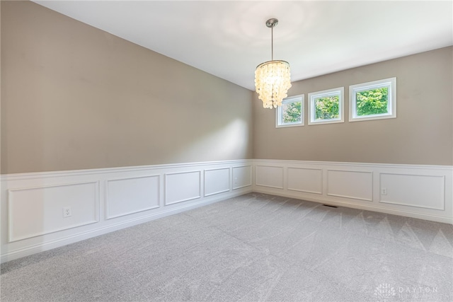 225 Woodstream Dr, Springboro, OH 45066 - unfurnished room featuring a chandelier, a decorative wall, light carpet, and wainscoting