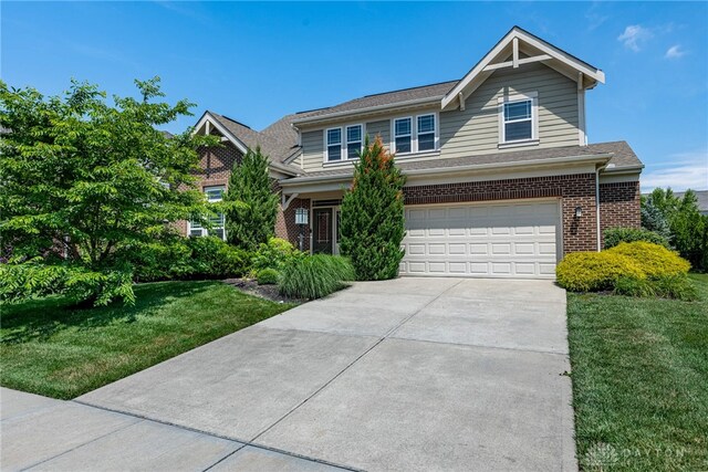225 Woodstream Dr, Springboro, OH 45066 - view of front of home featuring an attached garage, brick siding, driveway, and a front yard