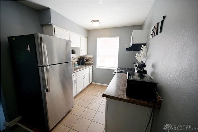 228 E Bruce Ave, Dayton, OH 45405 - kitchen featuring freestanding refrigerator, white cabinets, decorative backsplash, and under cabinet range hood