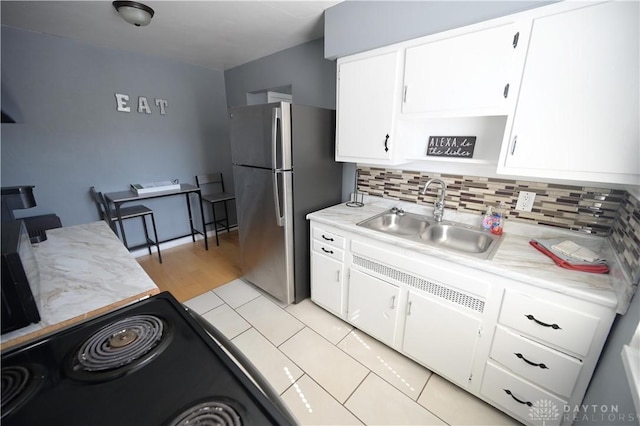 228 E Bruce Ave, Dayton, OH 45405 - kitchen featuring freestanding refrigerator, light countertops, white cabinetry, and backsplash
