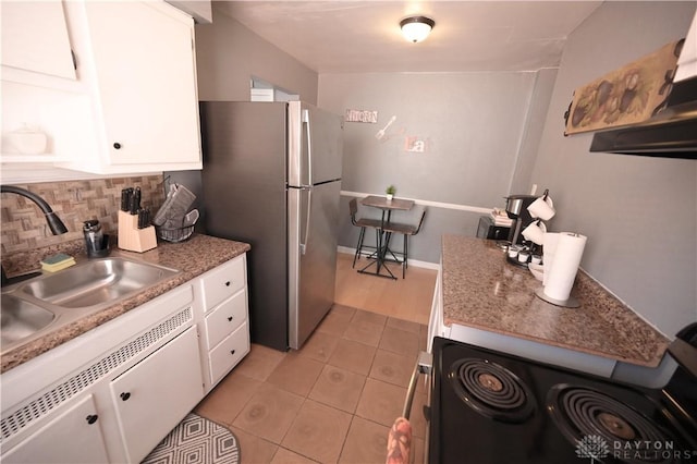 228 E Bruce Ave, Dayton, OH 45405 - kitchen featuring range with electric stovetop, backsplash, white cabinets, and light tile patterned floors