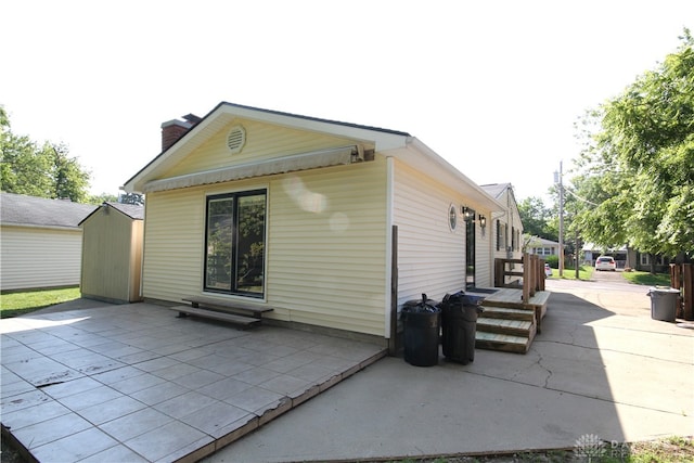 412 Cedar Ln, Lebanon, OH 45036 - rear view of house featuring a patio area, a shed, and a chimney