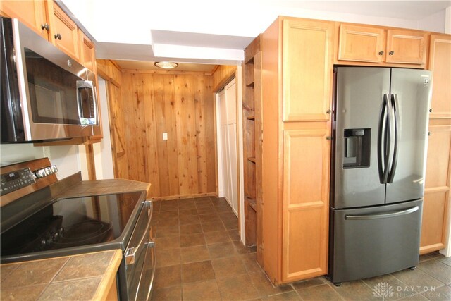412 Cedar Ln, Lebanon, OH 45036 - kitchen with stainless steel appliances, tile counters, wood walls, and light brown cabinetry