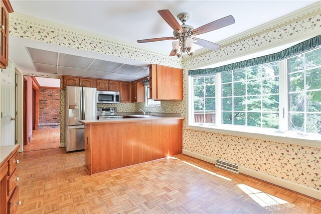 798 Carini Ln, Cincinnati, OH 45218 - kitchen featuring stainless steel appliances, a peninsula, ceiling fan, wallpapered walls, and light countertops