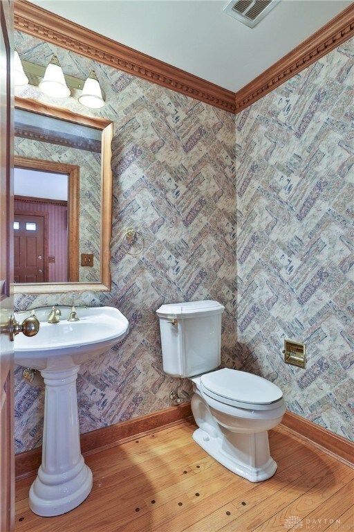 798 Carini Ln, Cincinnati, OH 45218 - bathroom with wood finished floors, crown molding, and wallpapered walls