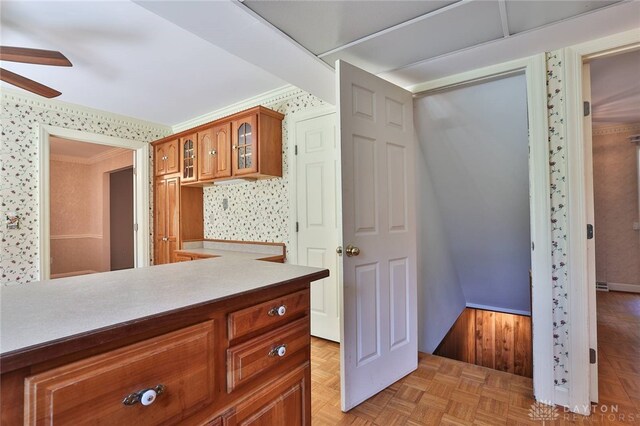798 Carini Ln, Cincinnati, OH 45218 - kitchen with ceiling fan, brown cabinets, glass insert cabinets, light countertops, and ornamental molding
