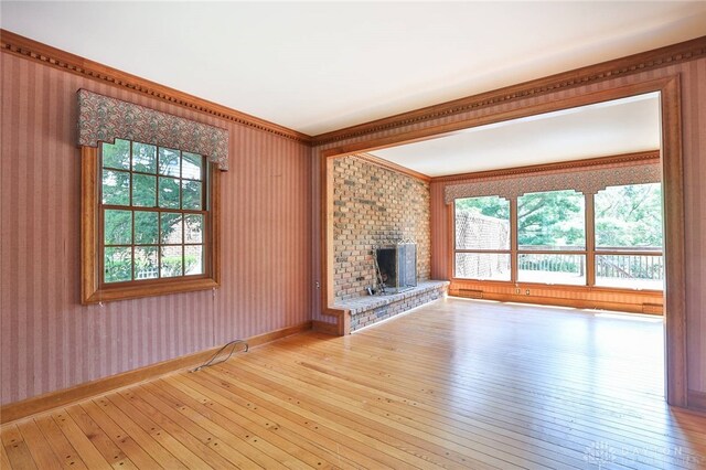 798 Carini Ln, Cincinnati, OH 45218 - unfurnished living room featuring ornamental molding, plenty of natural light, wood-type flooring, and a fireplace