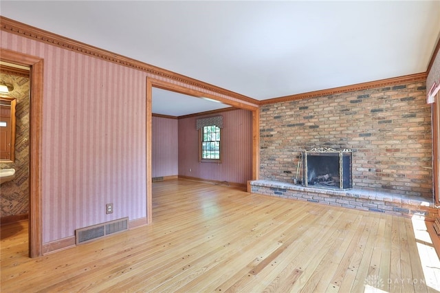 798 Carini Ln, Cincinnati, OH 45218 - unfurnished living room featuring ornamental molding, hardwood / wood-style floors, and a brick fireplace