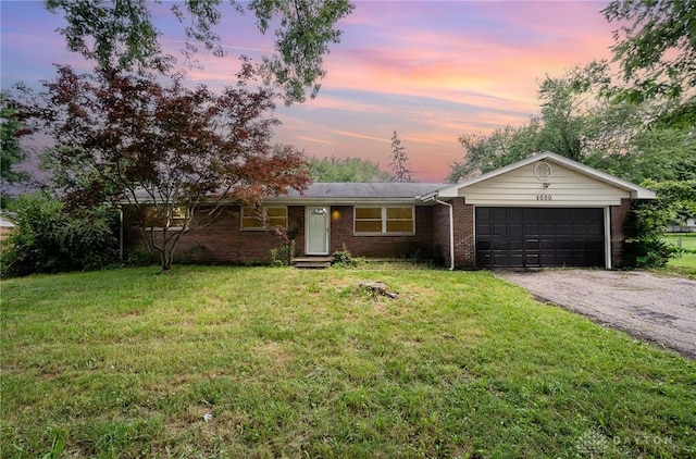 4689 Fisher Rd, Franklin, OH 45005 - ranch-style home with an attached garage, brick siding, a front yard, and asphalt driveway