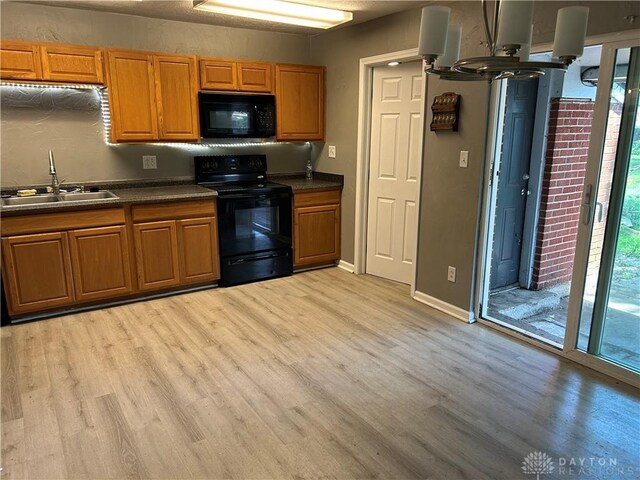 103 W Boitnott Dr, Englewood, OH 45322 - kitchen featuring black appliances, light wood-style floors, dark countertops, and plenty of natural light
