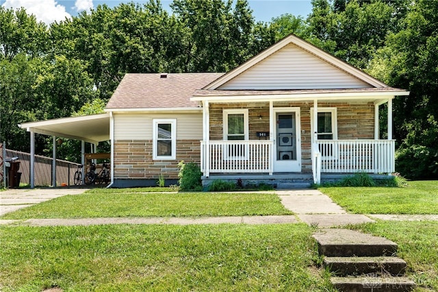 541 E Main St, Xenia, OH 45385 - view of front of house featuring covered porch, a front lawn, a shingled roof, an attached carport, and concrete driveway