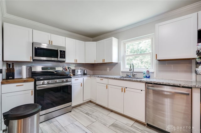 541 E Main St, Xenia, OH 45385 - kitchen with appliances with stainless steel finishes, white cabinets, backsplash, ornamental molding, and light stone countertops