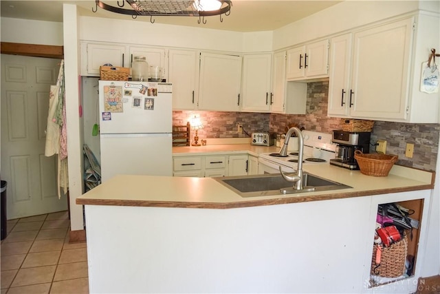 4741 Wolverton Rd, Eaton, OH 45320 - kitchen featuring freestanding refrigerator, a peninsula, backsplash, and light tile patterned floors