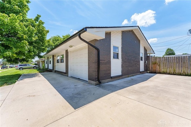 1110 Langdale Ave, New Carlisle, OH 45344 - view of side of property with driveway, brick siding, and an attached garage