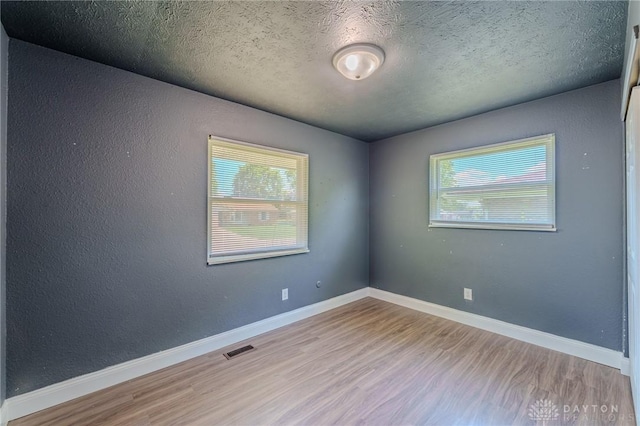 1110 Langdale Ave, New Carlisle, OH 45344 - spare room with wood finished floors and a textured ceiling