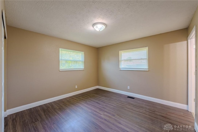 1110 Langdale Ave, New Carlisle, OH 45344 - spare room featuring healthy amount of natural light, dark wood-style floors, and a textured ceiling
