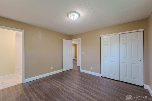 1110 Langdale Ave, New Carlisle, OH 45344 - unfurnished bedroom featuring wood finished floors, a textured ceiling, and a closet