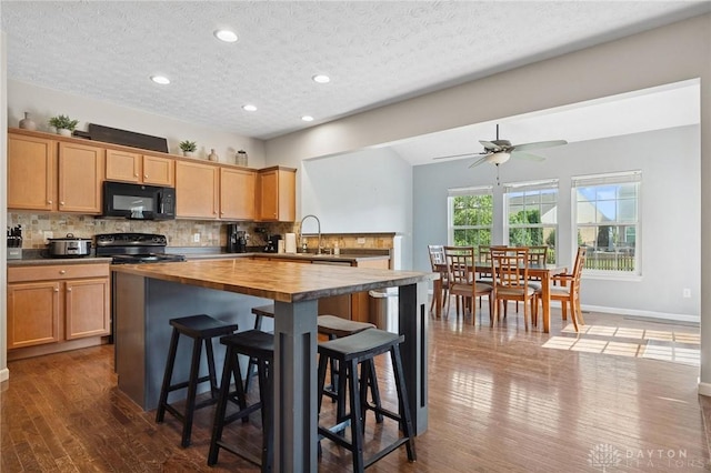 1681 S Branch Rd, Clearcreek Twp, OH 45458 - kitchen featuring black appliances, wooden counters, backsplash, wood finished floors, and a textured ceiling