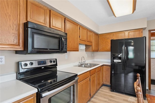 442 Kirkwood Dr, Fairborn, OH 45324 - kitchen featuring black appliances, light countertops, light wood-style flooring, and brown cabinets