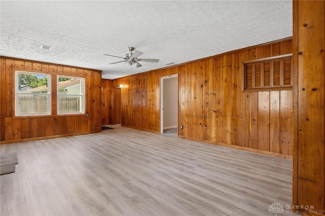 442 Kirkwood Dr, Fairborn, OH 45324 - unfurnished living room featuring ceiling fan, wood finished floors, a textured ceiling, and wooden walls