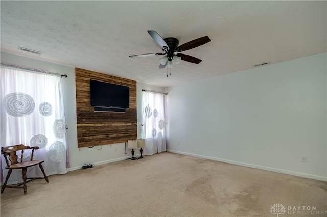 2933 E Ambrosia Ln, Xenia, OH 45385 - unfurnished living room with healthy amount of natural light, carpet floors, a ceiling fan, and a textured ceiling