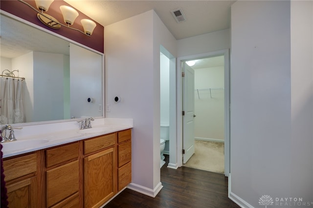 2933 E Ambrosia Ln, Xenia, OH 45385 - bathroom with wood finished floors, double vanity, a walk in closet, and a shower with curtain