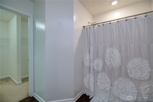 2933 E Ambrosia Ln, Xenia, OH 45385 - full bath featuring a shower with curtain, wood finished floors, and a walk in closet