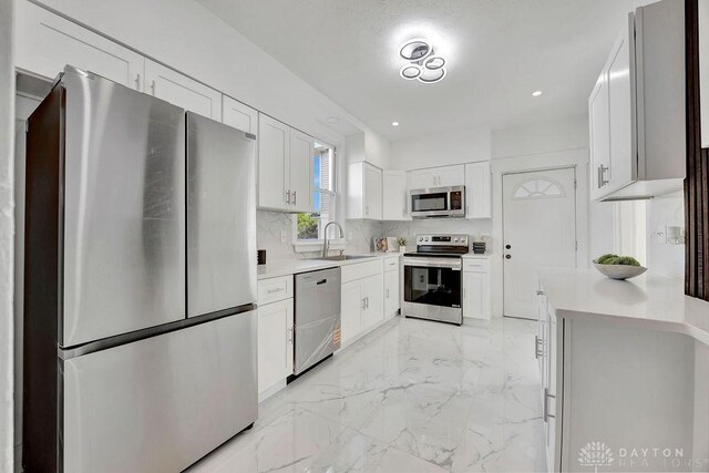 1200 Wyoming St, Dayton, OH 45410 - kitchen featuring appliances with stainless steel finishes, light marble finish flooring, white cabinets, light countertops, and recessed lighting