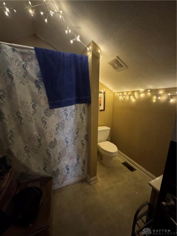428 E Center St, Germantown, OH 45327 - bathroom featuring lofted ceiling, tile patterned floors, a textured ceiling, a shower with shower curtain, and vanity