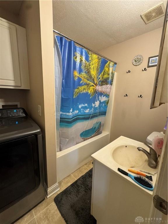 428 E Center St, Germantown, OH 45327 - bathroom with washer / dryer, shower / tub combo with curtain, tile patterned flooring, vanity, and a textured ceiling