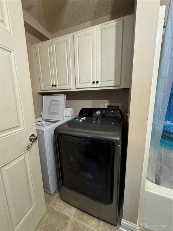 428 E Center St, Germantown, OH 45327 - laundry room with washing machine and clothes dryer, light tile patterned floors, and cabinet space