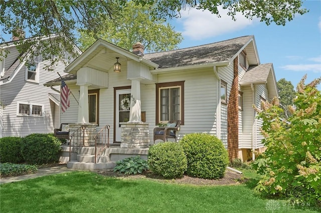439 Monteray Ave, Oakwood, OH 45419 - bungalow-style home featuring a chimney, a front yard, roof with shingles, and covered porch